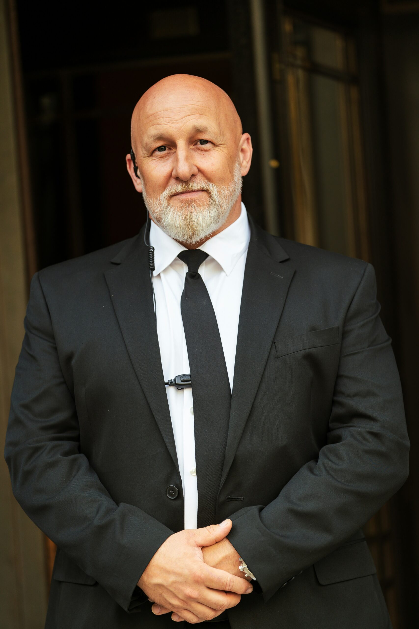 A man in a suit and tie standing in front of a door