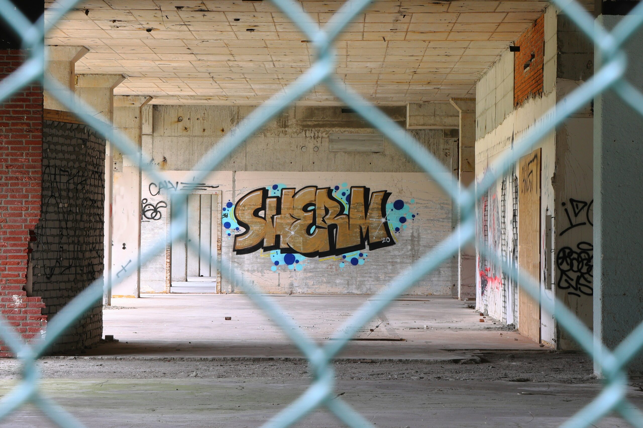 grey metal fence with graffiti