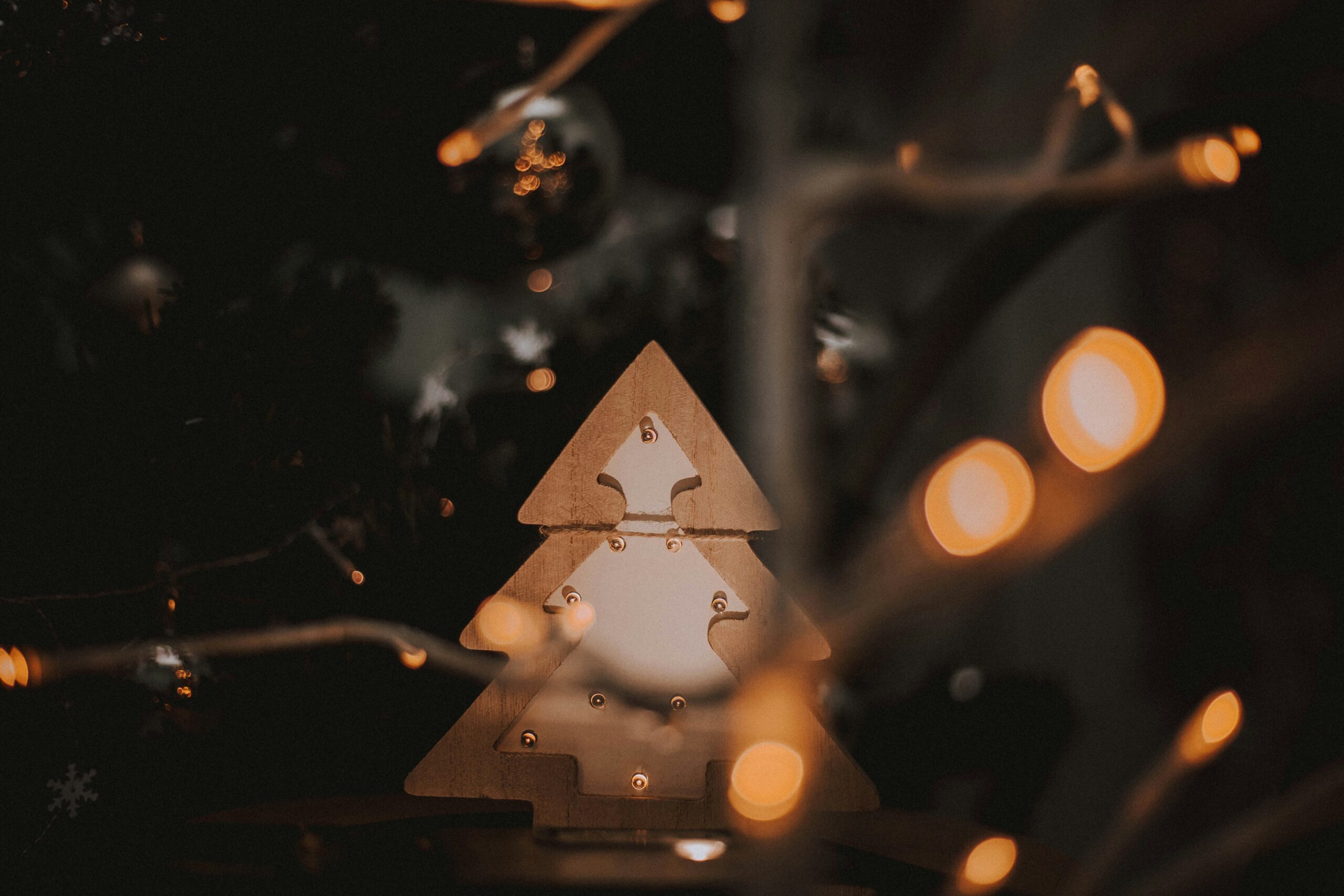 a wooden christmas tree with lights around it