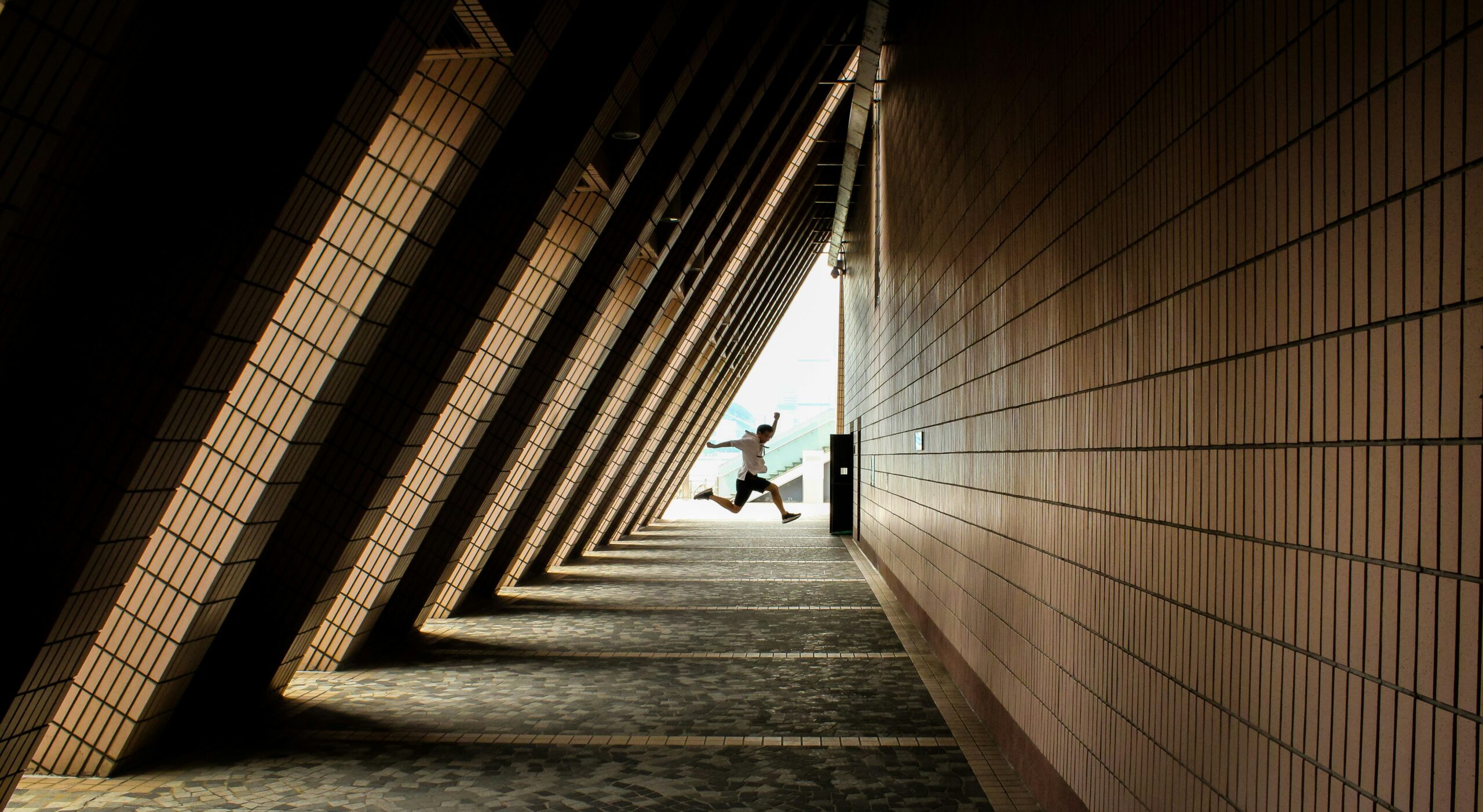 person jumping in building during daytime